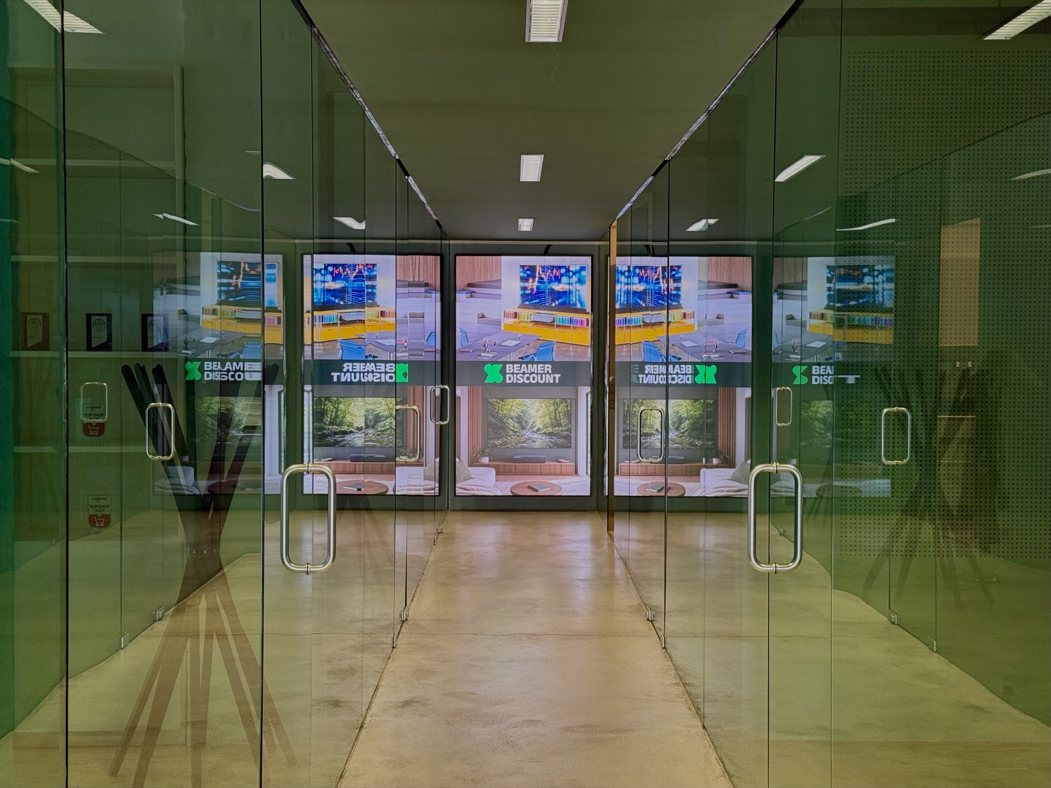Schmaler Flur mit einem 100-Zoll-Digital-Signage-Display im Hochformat am Ende des Gangs