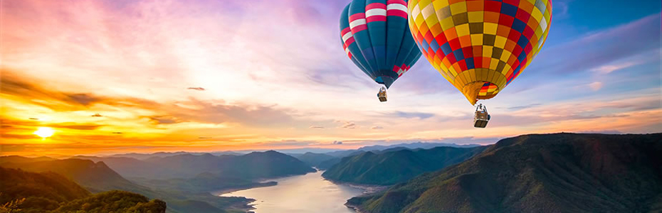 Bild in 4K UHD Auflösung von zwei Heißluftballons die in den Sonnenaufgang fliegen