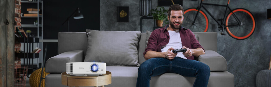 Gamer im Wohnzimmer mit dem Beamer zur linken Seite